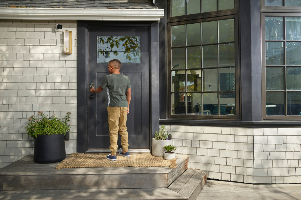 boy entering code on door lock