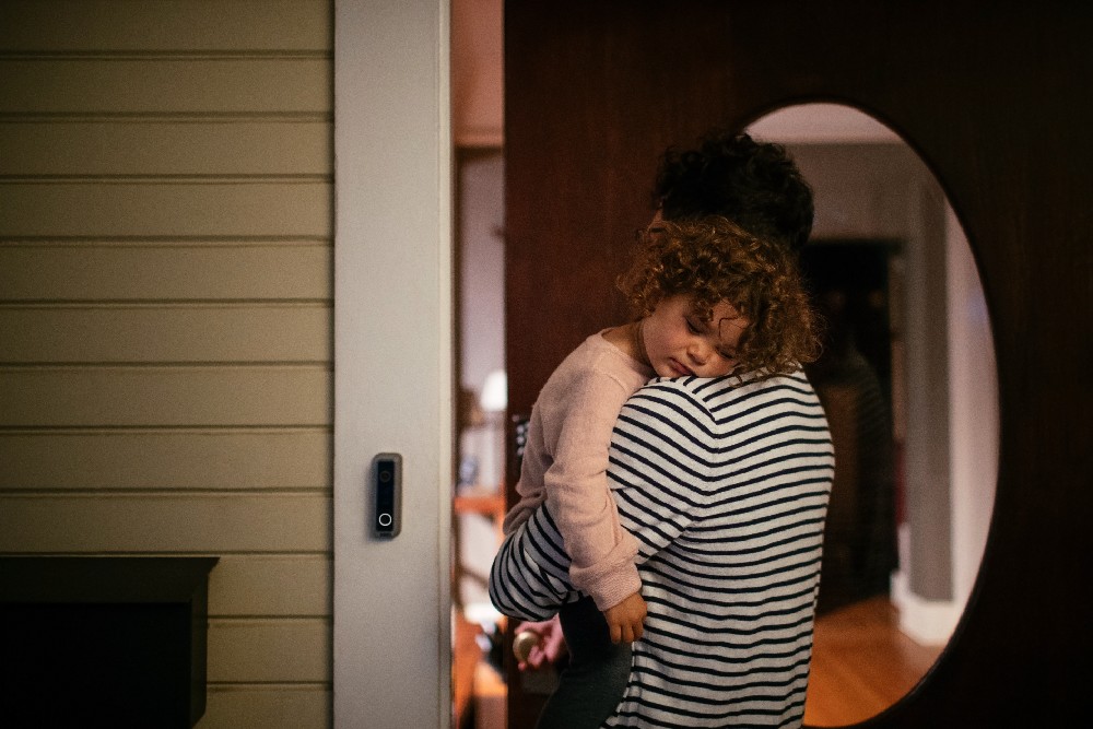 dad holding kid walking in the front door