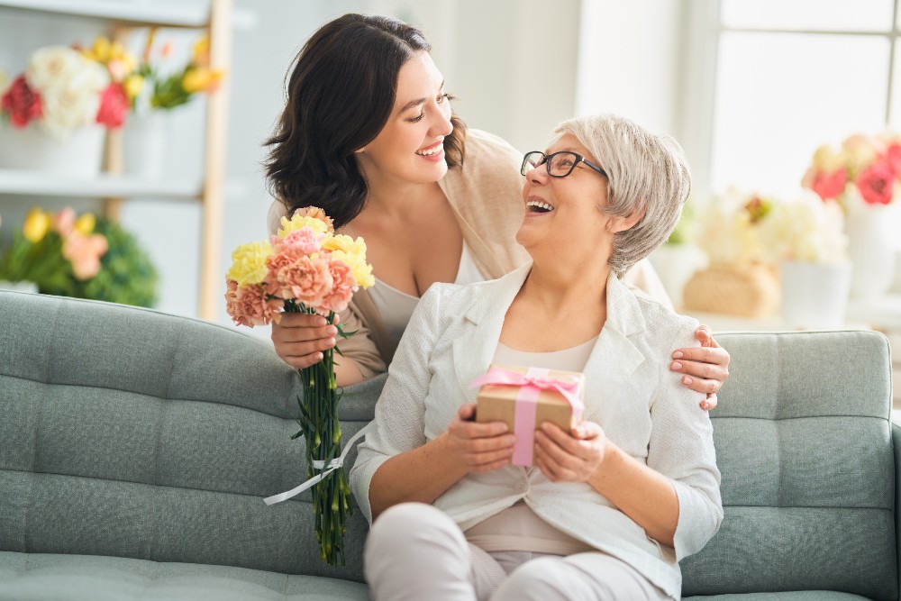 daughter giving flowers to mom