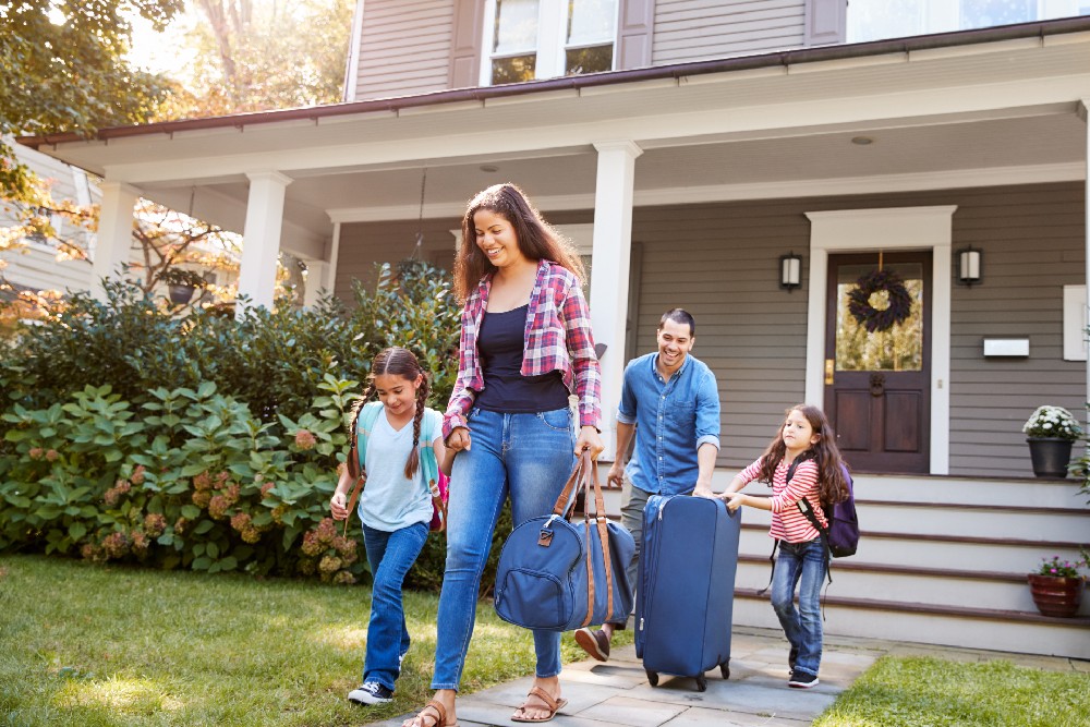 family with luggage leaving home