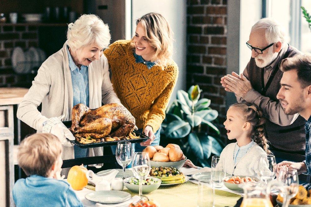 grandma with turkey with family at table