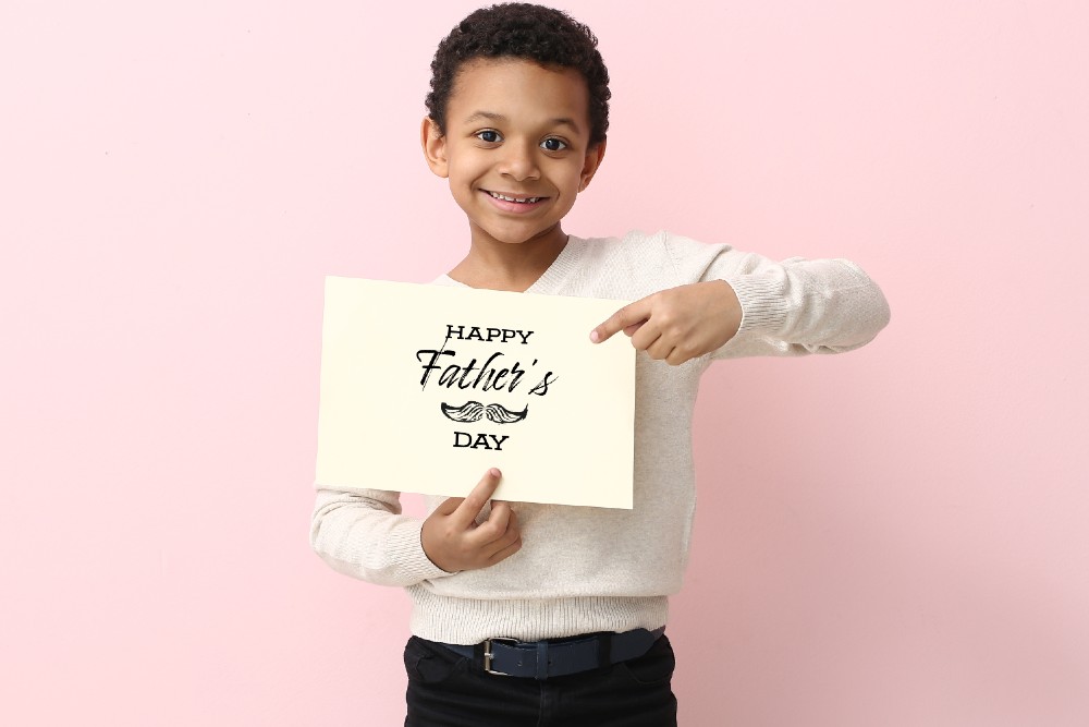 kid holding Happy Father's Day card