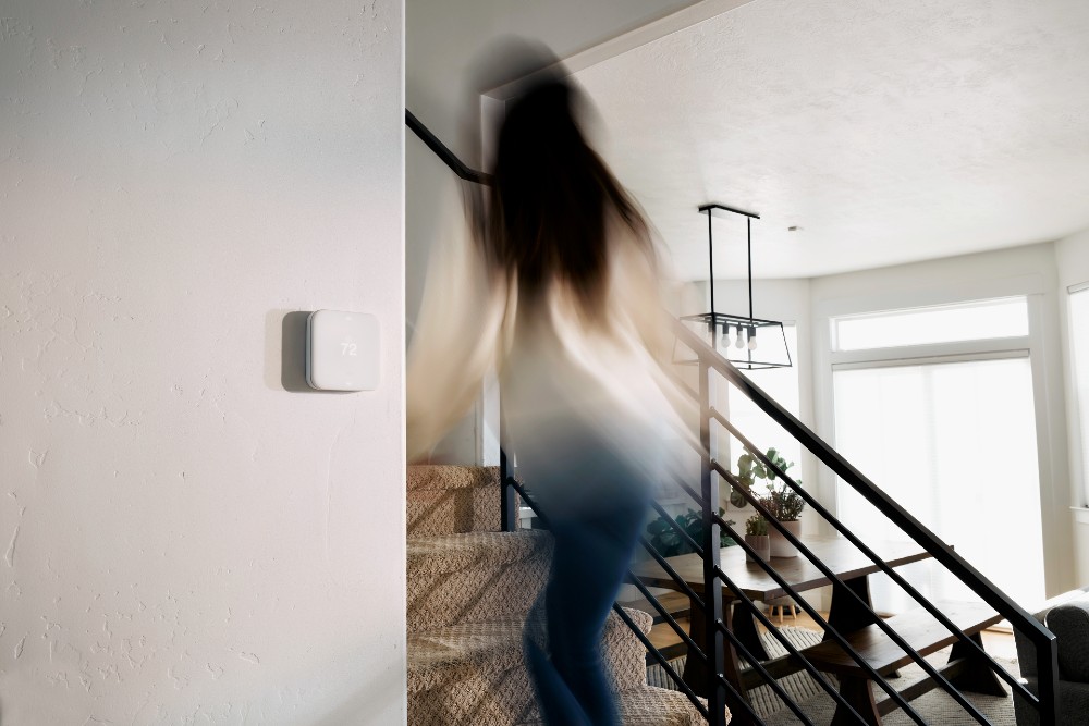 vivint smart thermostat woman going up stairs
