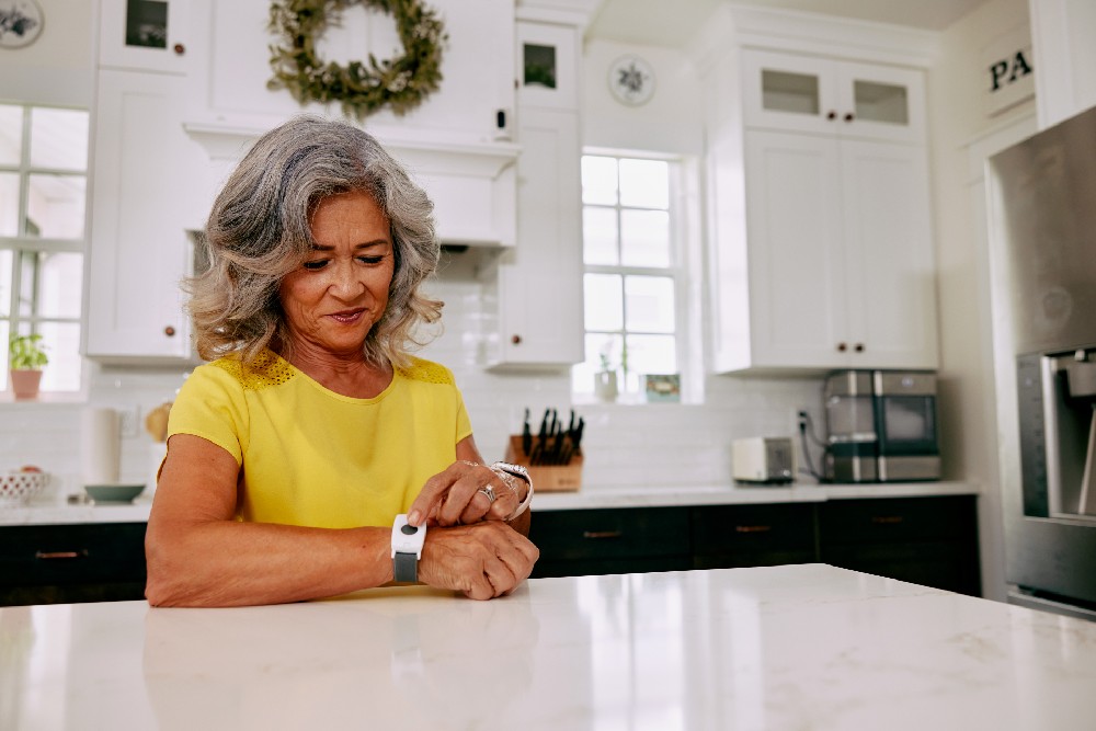 woman with emergency pendant wrist in kitchen