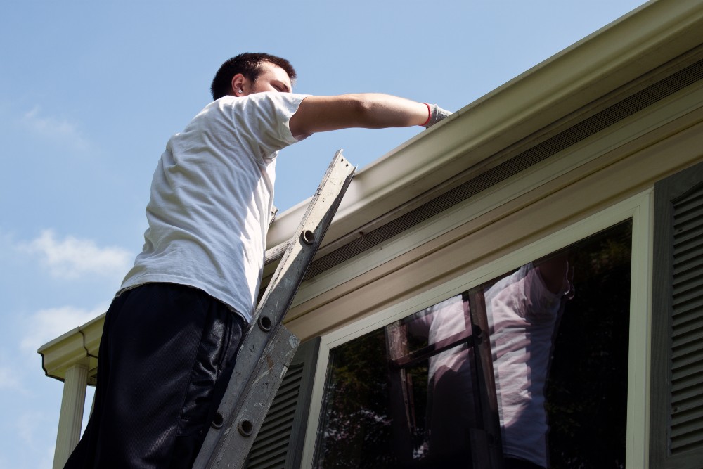 man cleaning gutter