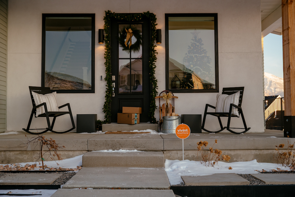 packages on porch with Christmas tree in window