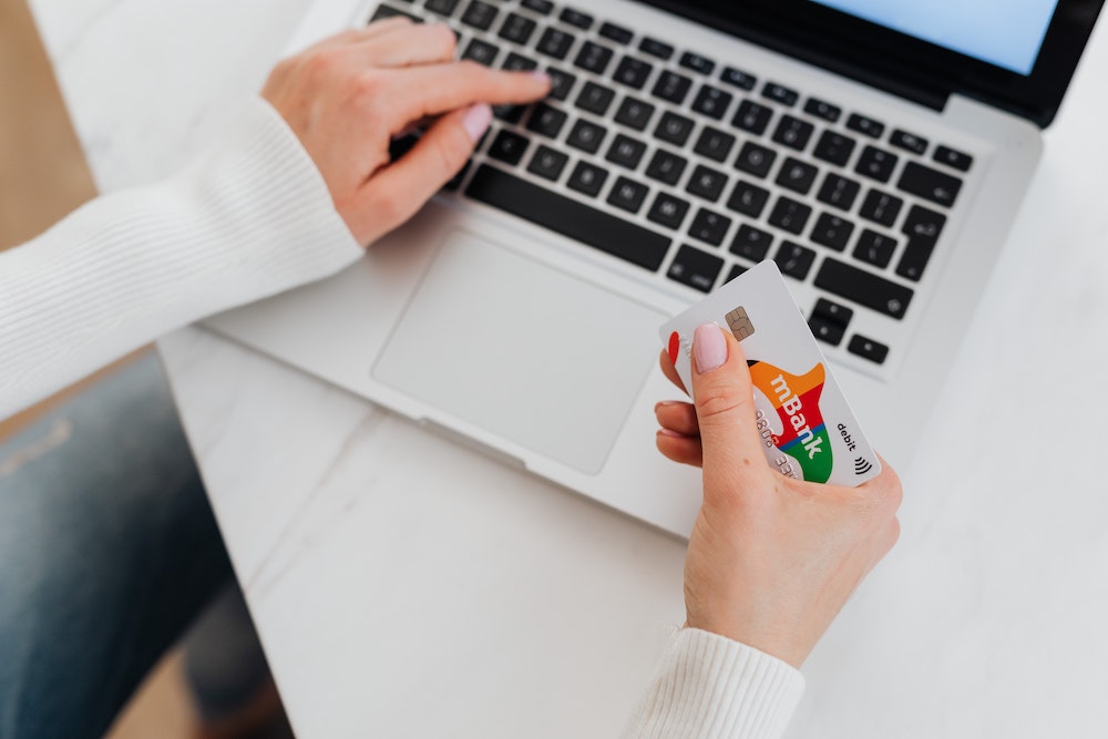 woman with debit card on laptop